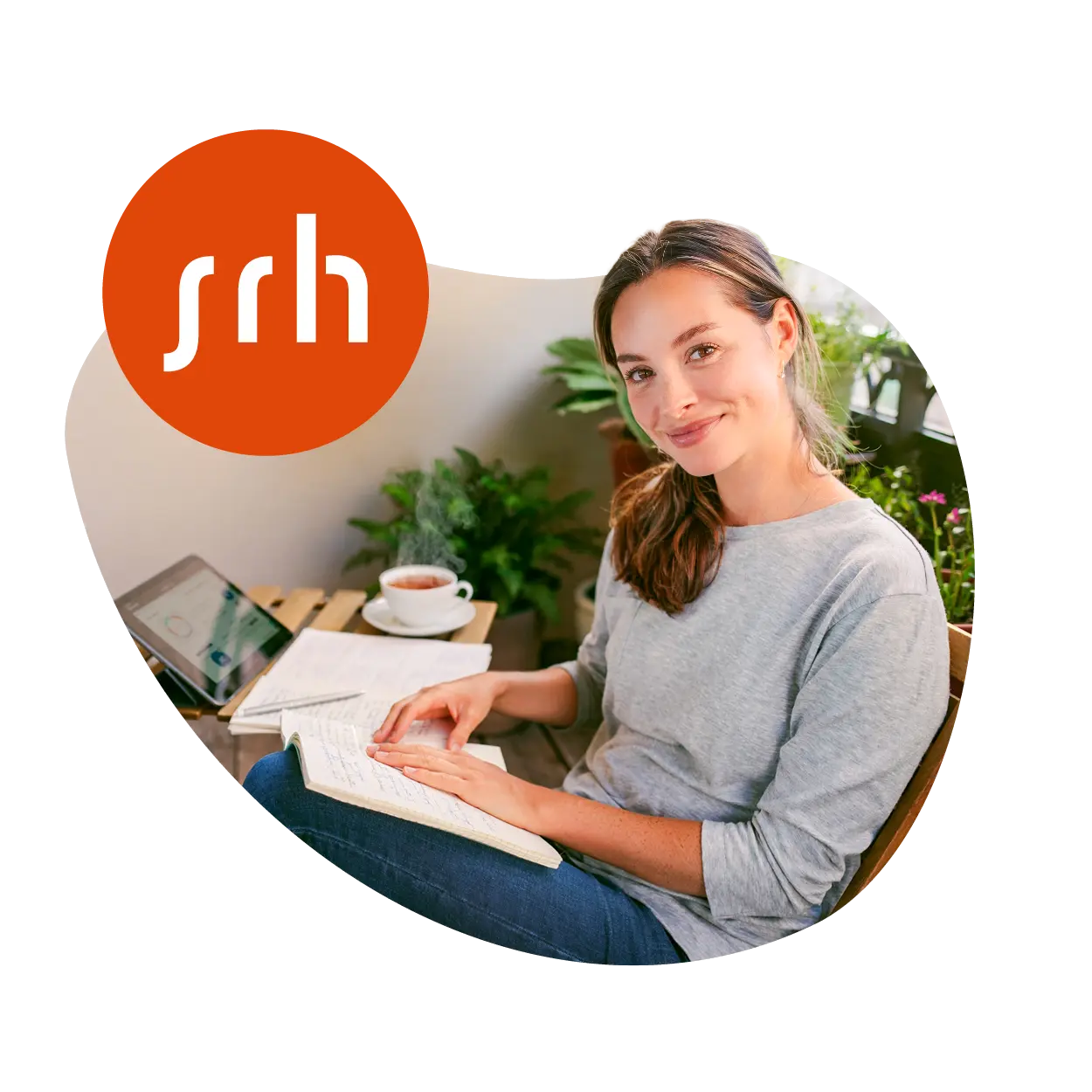 Eine Frau sitzt entspannt auf ihrem Balkon und lernt