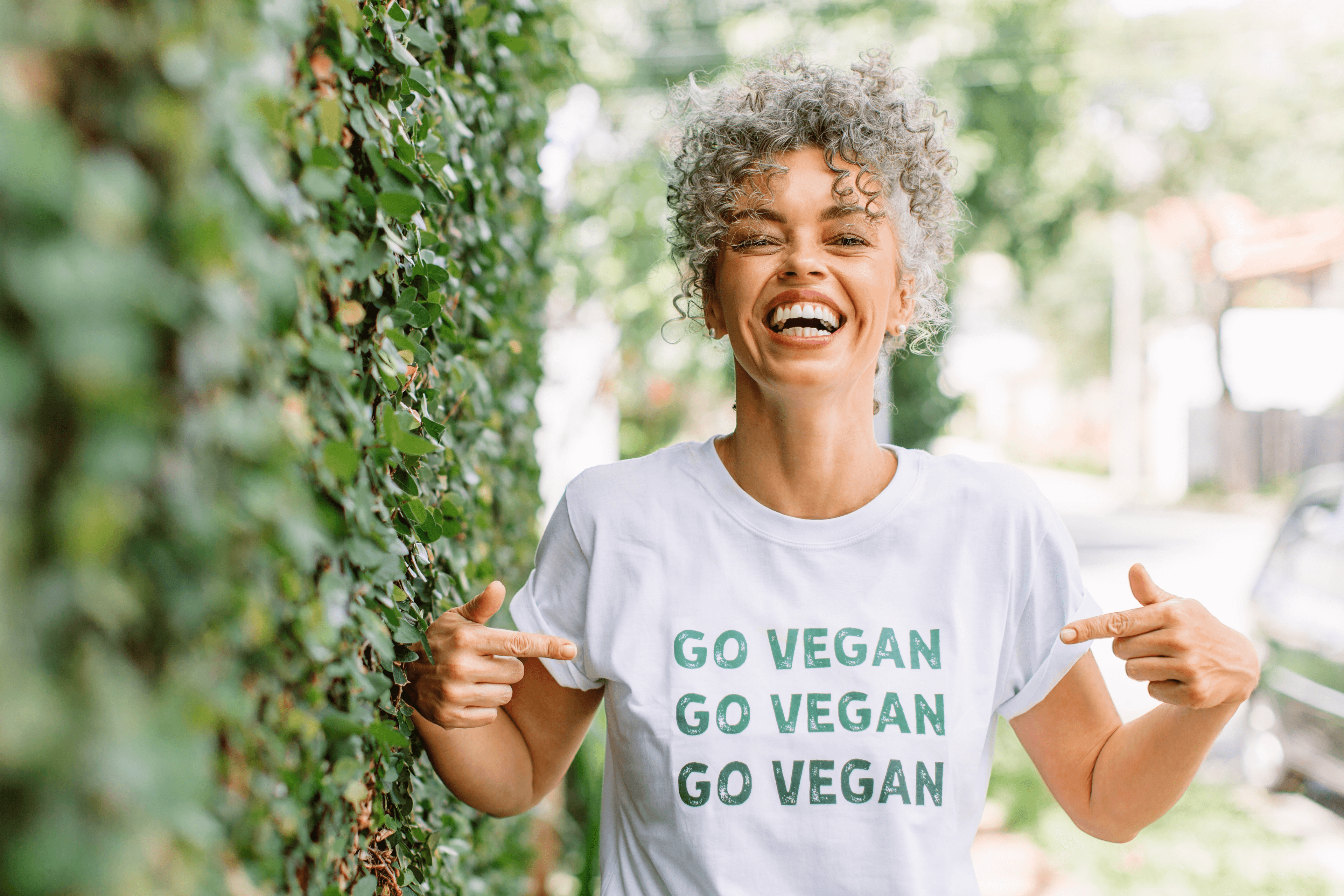 lachende Frau mit einem T-Shirt mit der Aufschrift "Go Vegan"