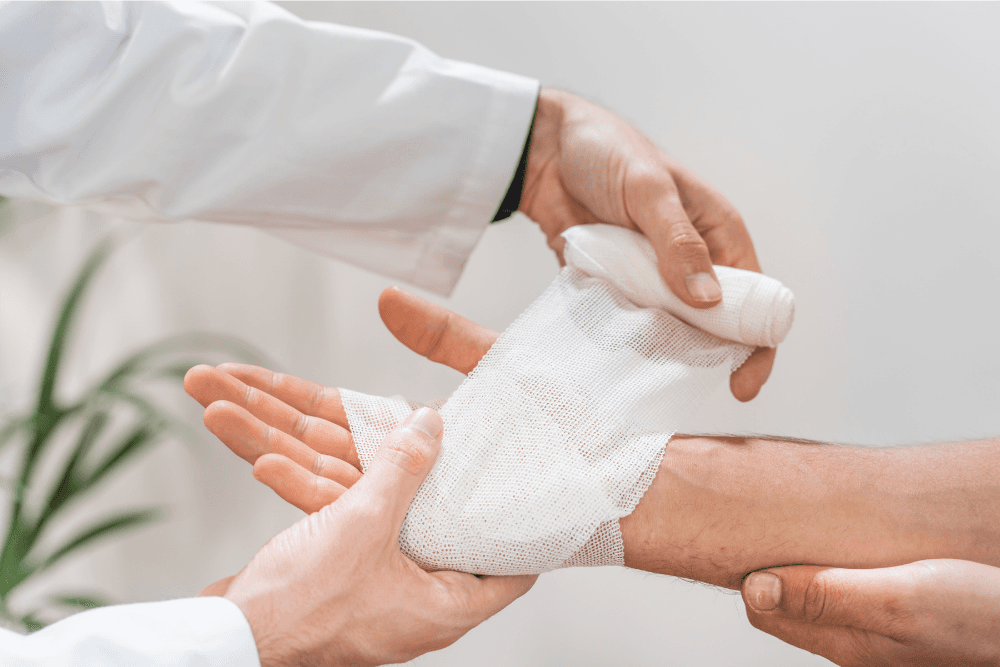 Eine Pflegefachkraft verbindet einen Arm mit einer Mullbinde